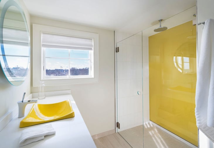Glass shower door with yellow back painted glass