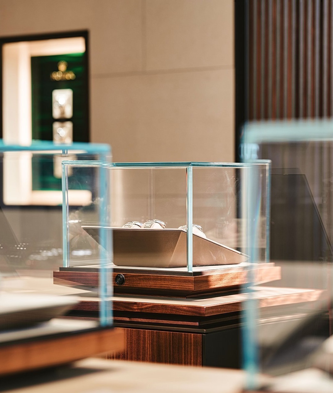 2 blurred glass displays in foreground with focused glass display of watches in background