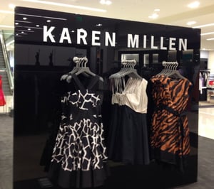 Black Back Painted Glass with sign - Karen Millen and dresses hanging on racks in front