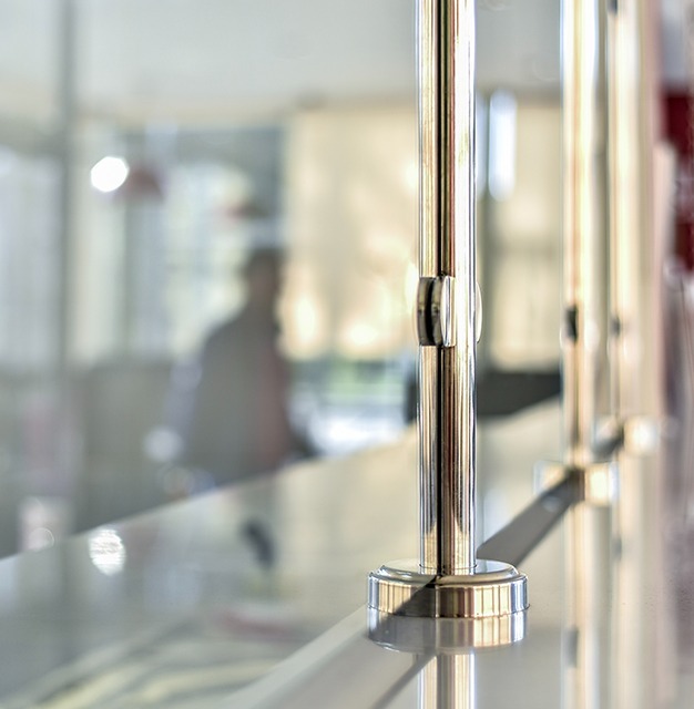 Close up of sneeze guard glass with joining metal piece