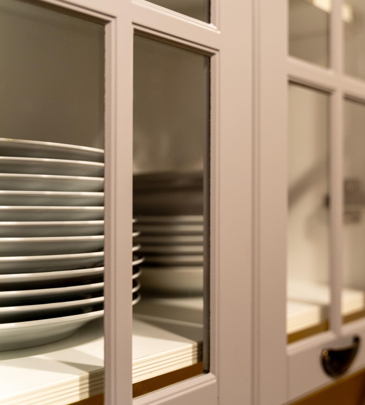 Closeup of cabinet glass with plates stacked inside