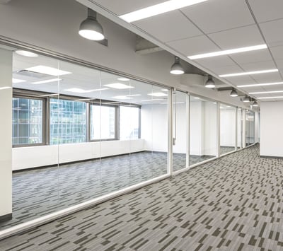 Full glass office in brightly lit office building floor
