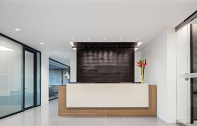 Reception desk next to office with glass office walls