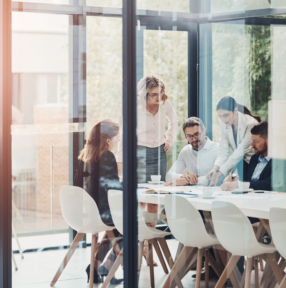 Employees talking behind soundproof glass in office