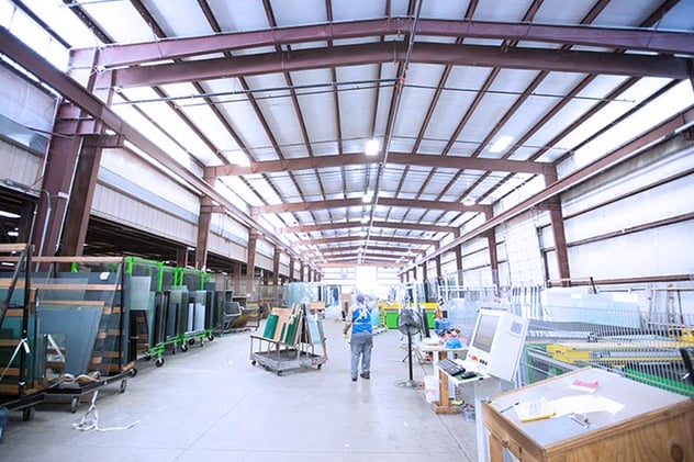 Wide view of Warehouse with workers and palletes of glass