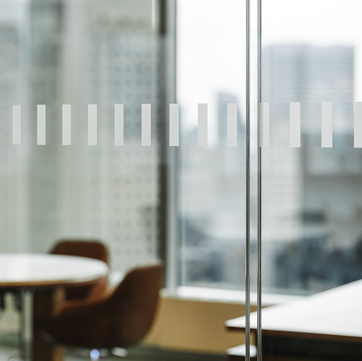 Close up of modern office doors with decorative lines and blurred background of office chairs