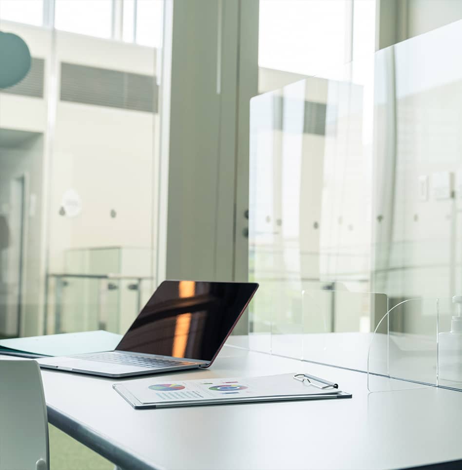 Modern medical office with glass divider, glass walls and laptop with clipboard on table